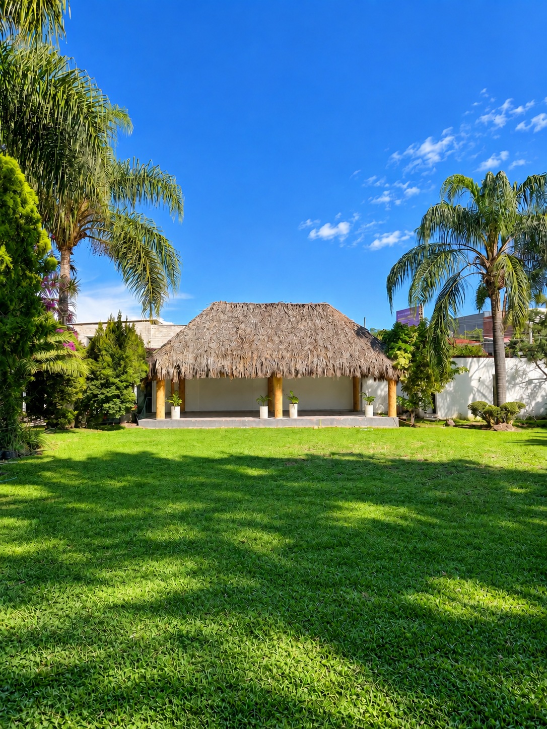 Jardín de Los Faisanes con palapa y palmeras